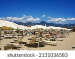 Small photo of LIDO DI CAMAIORE, ITALY - Aug 17, 2014: A lot of people relaxing at the beach on a warm summer day in Lido di Camaiore, Italy