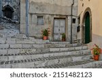 Small photo of A beautiful shot of medieval stairs with pot plants among the houses of Patrica village in Lazio region, Italy