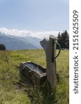 Small photo of A vertical shot of a fount for drinking water in the field in Switzerland Falera Graubunden Grisons