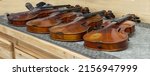 A Row Of Violins On The Table