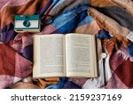 Small photo of FORSYTH, UNITED STATES - Aug 19, 2019: A top view of a vintage camera, book, and a watch on a blanket