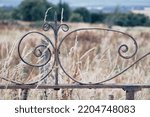 Small photo of Closeup details of an old mangled wrought iron metal gate