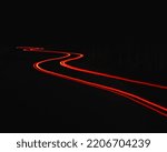 A winding car light trail in the darkness