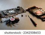 Small photo of POZNAN, PL - Oct 01, 2022: Disassembled graphics card XFX GPU AMD fan screws screwdriver on a table