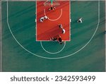 Small photo of An aerial top view of a basketball court and young people playing the game