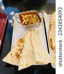Small photo of A vertical high-angle shot of a saucy dish served with pieces of Flatbread