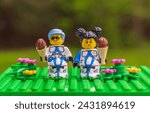 Small photo of Chappaqua, NY - May 9, 2023: Cute blue haired and pigtailed Lego minifigure Star Wars kid Clone Troopers helmets off a taking a break to eat ice cream cones. Humor individuality concepts