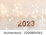 Holiday background Happy New Year 2023. Numbers of year 2023 made by gold candles on bokeh festive sparkling background. celebrating New Year holiday, close-up. Space for text
