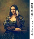 Small photo of Phone talking. Young woman as Mona Lisa, La Gioconda isolated on dark green background. Retro style, comparison of eras concept. Beautiful female model like classic historical character, old-fashioned
