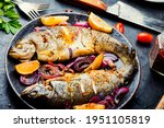 Roasted trout with lemon and onion on plate
