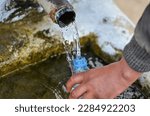 Small photo of Bizerte, Tunisia, 04 April 2023: A man fills bottles with water from a fountain connected to the Lake of Ain Damous in the city of Bizerte, amid a major drought in Tunisia. (Photo by Hasan Mrad) 