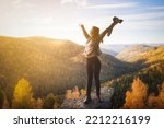 happy woman photographer spreading arms and watching the mountain. Travel Lifestyle success concept adventure active vacations outdoor freedom emotions.