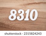 Small photo of White number 8310 on a brown and light brown wooden background.