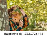 Portrait Of An Anonymous Young Woman Covering Her Face With Dried Leaves.