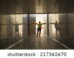 Rear view of a male dock worker opening the doors of a cargo container