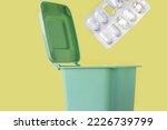 Small photo of plastic blister thrown in mini small trash garbage bin can.expired pills blister with removed missing tablets isolated.unused or expired medicine drop off recycle.safe drug disposal.get rid throw away