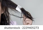 Small photo of woman applying serum oil on wet hair with pipette or using white comb to disentangle isolated.healthy strong hair,growth stimulation stop fall shiny.top of head forehead lateral view.after pregnancy