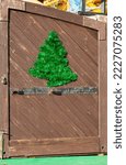 Small photo of A fragment of green tinsel happy New Year on a wooden background. The tinsel is laid out in the shape of a fir tree
