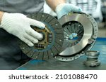 Small photo of Car spare parts. The clutch kit is in the hands of an auto mechanic. Monitoring of the technical condition of the drive disc, the driven disc and the exhaust bearing. Repair and maintenance in a car s