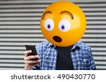 Surprise emoji head man using a smartphone. Emoji concept
