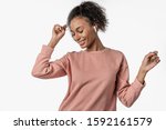 African woman wearing airpods listening music and dancing isolated over white background