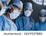 Small photo of Concentrated surgeons operating patient in operating theatre. Healthcare workers concept.