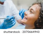 Small photo of Perfect ideal dreamy smile. Preteen caucasian boy visiting dentist orthodontist, doing doctor`s teeth tooth mouth cavity checkup in clinic