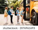 Small photo of Multiethnic pupils classmates schoolchildren students standing in line waiting for boarding school bus before starting new educational semester year after summer holidays