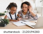 Small photo of African-american mom mother tutor nanny childminder helping assisting with homework school project to a preteen daughter. Homeschool concept. E-learning on laptop