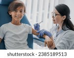 Small photo of Female doctor pediatrician injecting vaccine to little boy in medical clinic for receiving anti-bodies, immunization boost. Vaccination against coronavirus, hepatitis, flu, measles, chicken pox