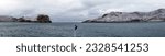 Small photo of Deception Island, Antarctica - March 4, 2022: Panorama of the flag flying on the bow of a cruise ship, with the snow covered mountains around the pass at Deception Island in the distance