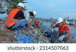 Small photo of jepara, central java, indonesia, 07 may 2023, three people sorting garbage in a seedy river