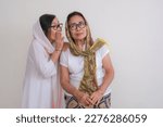 Small photo of Two adult Asian women gossiping together and sharing hoax