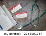 Small photo of 03.06.2022 Germany A Drug box of Morphine,pain medication of the opiate.On a table and in the background a medical book.