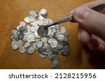 Small photo of A treasure trove of silver coins from the reign of Ivan 4 the Terrible. Medieval money of Russia in the hands of a collector. Study and attribution of coins. Numismatics, collecting.