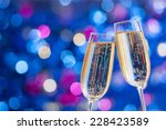 Two glasses of champagne with lights in the background. Very shallow depth of field. Selective focus.