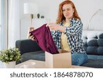 Small photo of Embittered woman opening just delivered item after home shopping