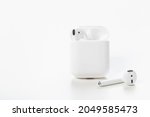 Modern wireless bluetooth earphones with charging case on a white background. The concept of modern technology.
