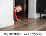 Child, toddler, little boy playing hide and seek at home. Joy at home, cozy heated floor. Creative indoors activities for kids.