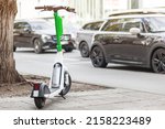 Electric Ride Sharing Scooter. Dockless scooter for rent on street on background of cars. Urban bicycle transport