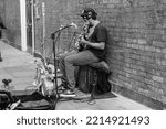 Small photo of busker on the streets of Spitalfields Market, London, UK - 17 Oct 2022