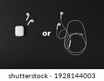 Wireless headphones or wired. The concept of choosing between two types of headphones. White headphones on a black background.