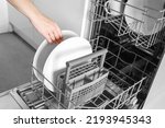  Loading dishes. Dishwashing capsules. Open dishwasher with clean dishes in the white kitchen. Opening and closing the dishwasher.
