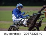 Small photo of GRONINGEN NETHERLANDS - AUGUST 1st, 2021: Riders compete during their harness racing or horse sulky race at the "Royal Drafbaan Groningen"