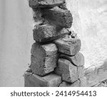 Small photo of Fragment of a wall made of logs. Log house corner. Fragment of a wall made of logs. Wall of an eco-friendly wooden house. Tow between the logs on the wall of the old house.Black and white photo.