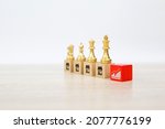 Small photo of Franchise or franchising, King chess standing with on cube wooden block stack with graph and franchises business store icon for growth and products or services or branch expansion bank loan.