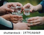 people celebrating and toasting with shots of alcohol vodka outdoors