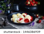 Cottage cheese dumplings with strawberries. Knedliki - czech cuisine. Fresh strawberry pot on dark background.