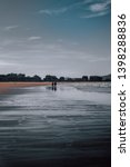 Small photo of image in which you can see a couple strolling along the beach with the clear sky with a slightly more tenuous edition of colors
