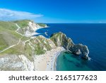 The drone aerial view of Durdle Door and beach. Durdle Door is a natural limestone arch on the Jurassic Coast near Lulworth in Dorset, England.